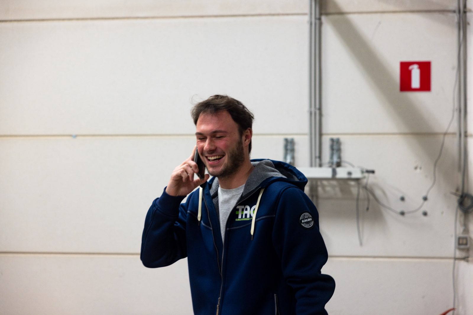 Collega lachend aan de telefoon in het magazijn