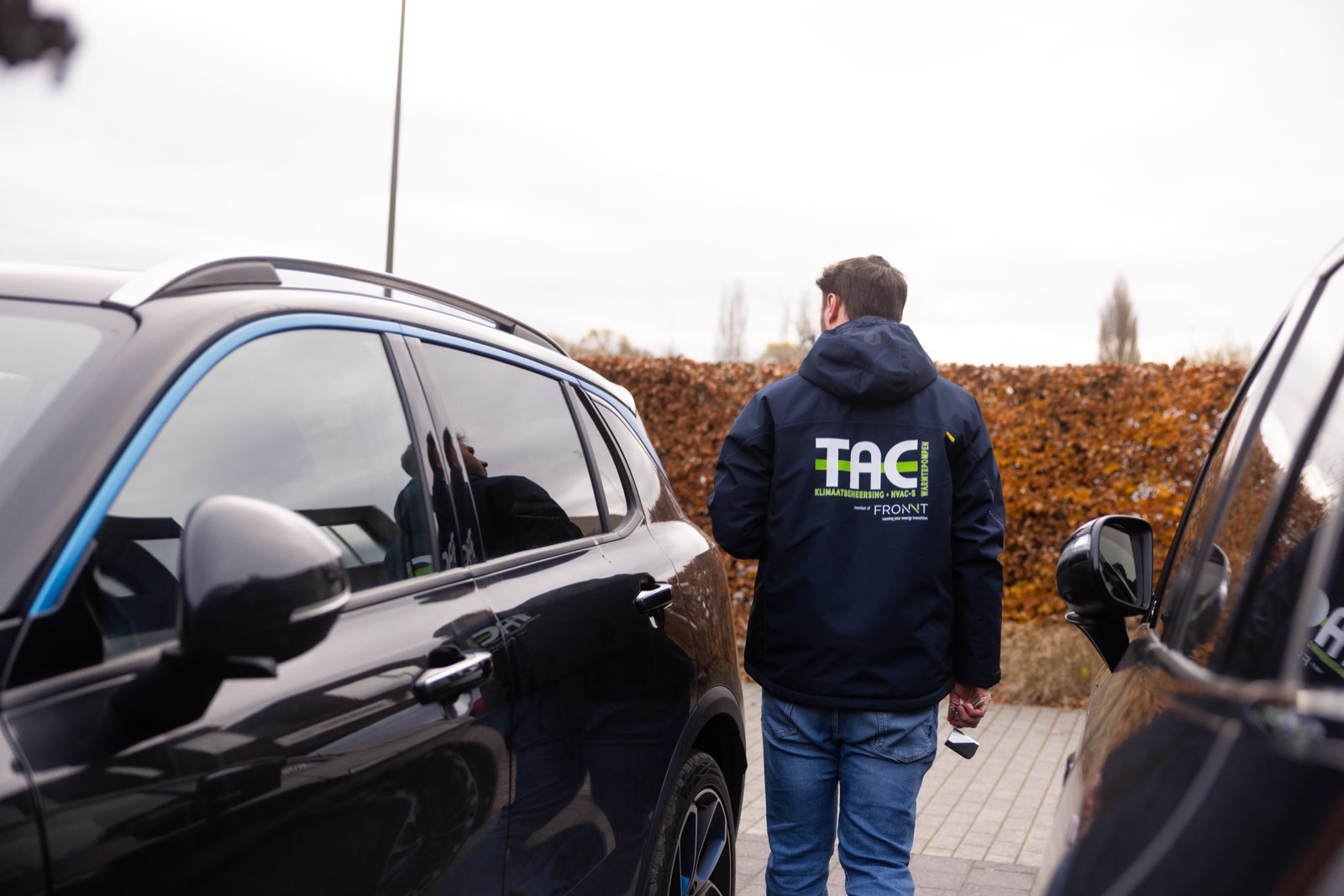 Collega met TAC-jas stapt in de bedrijfswagen
