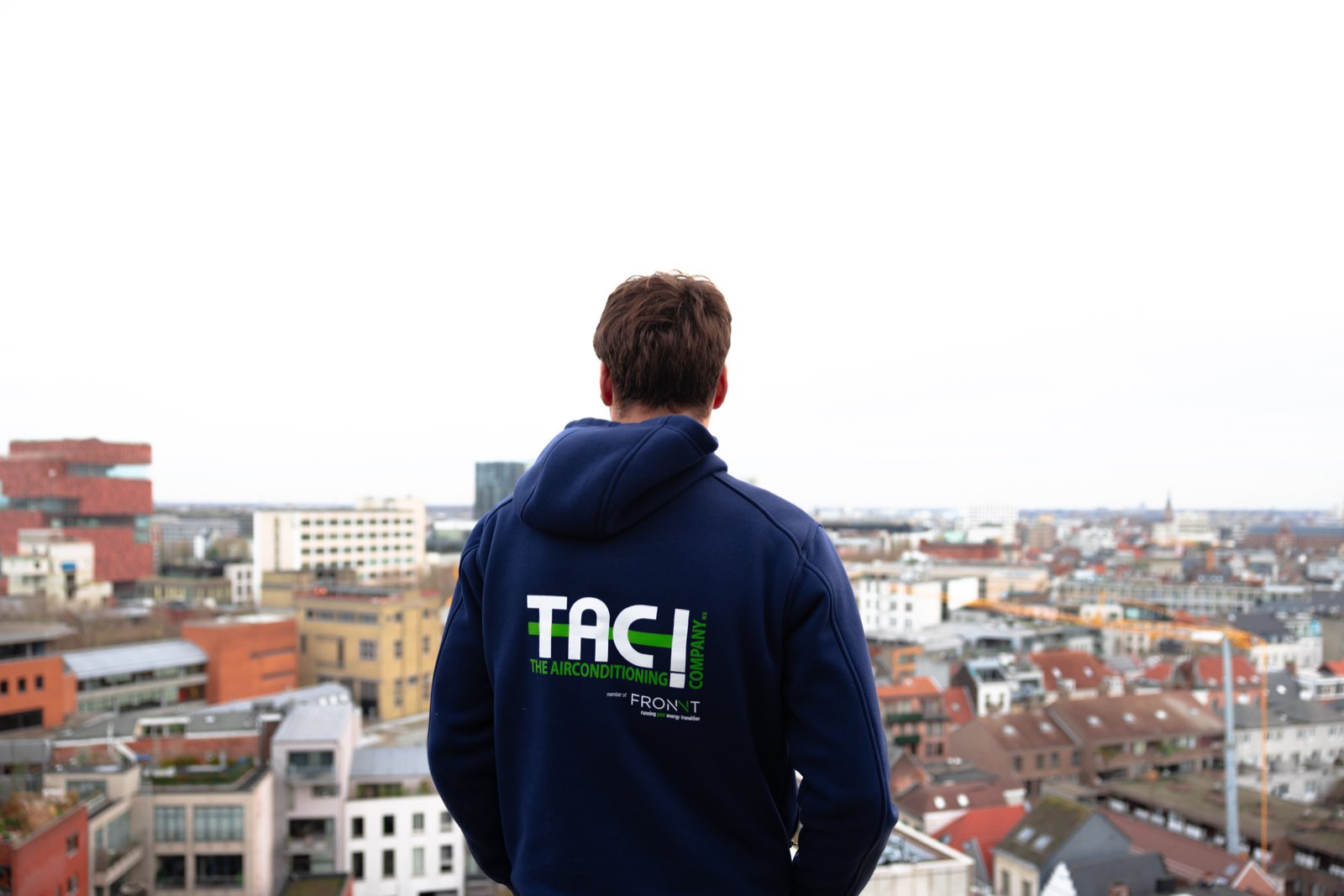 Collega kijkt uit over Antwerpen vanaf een dak